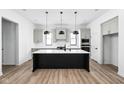 Modern kitchen with a large island, pendant lighting, and stainless steel appliances, perfect for culinary enthusiasts at 17354 Newton Main St, Westfield, IN 46074