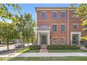 Brick townhouse with covered entry, set against a backdrop of lush greenery and blue skies at 2183 Glebe St, Carmel, IN 46032