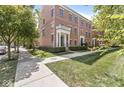 Traditional brick townhouse with manicured lawn and sidewalks, surrounded by mature trees at 2183 Glebe St, Carmel, IN 46032