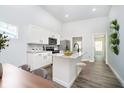 Bright kitchen featuring white cabinets, a granite island with seating, and stainless steel appliances at 238 N Tacoma Ave, Indianapolis, IN 46201