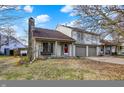 Charming two-story home with a red front door and a two-car garage nestled in a quiet neighborhood at 3051 Arrow Wood Ln, Indianapolis, IN 46214