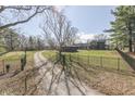 Gated entrance to a long driveway leading to the estate, surrounded by trees at 3357 Saddle Club Rd, Greenwood, IN 46143
