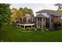 A spacious backyard with a screened in porch and patio with lush green grass at 3727 Tributary Ct, Westfield, IN 46062