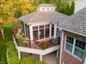 A screened in porch with an outdoor seating area and flower boxes that overlook the manicured yard at 3727 Tributary Ct, Westfield, IN 46062