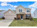 Beige two-story house with a two-car garage, brick accents, and a well-maintained lawn at 6075 Meadowview Dr, Whitestown, IN 46075