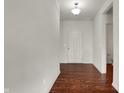 Entryway hallway with hardwood floors, white walls, and a view of the front door at 6075 Meadowview Dr, Whitestown, IN 46075