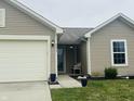 Close up of tan siding on a single-story home with a well-manicured lawn and landscaping at 6331 Enclave Blvd, Greenwood, IN 46143