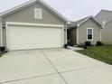 Single-story house with a two car garage and well maintained front yard at 6331 Enclave Blvd, Greenwood, IN 46143