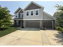 Charming two-story home with a three-car garage and well-manicured lawn, providing great curb appeal at 6345 Meadowview Dr, Whitestown, IN 46075