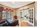 Office boasts hardwood floors, elegant wood trim, and a view through French doors at 6516 Shamel Dr, Indianapolis, IN 46278