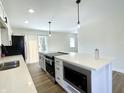 Modern kitchen features stainless steel appliances, a large island, and sliding glass doors to the backyard at 8525 E 42Nd Pl, Indianapolis, IN 46226