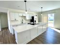 Bright kitchen features white cabinets, a central island with breakfast bar, and stainless steel appliances at 8525 E 42Nd Pl, Indianapolis, IN 46226