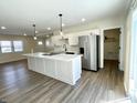 Spacious kitchen boasts an island with modern lighting, ample storage, and stainless steel appliances at 8525 E 42Nd Pl, Indianapolis, IN 46226