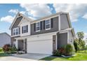 Attractive two-story home with a combination of brick and gray siding, offering a two car garage and landscaped front yard at 9723 Violet Cir, Indianapolis, IN 46239