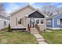 Charming bungalow with tidy landscaping, modern paint scheme and welcoming front steps at 1331 N Grant Ave, Indianapolis, IN 46201