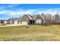 Beautiful brick home with a well-manicured lawn and a three car garage in a suburban neighborhood at 16075 Cobbs Crk Ln, Noblesville, IN 46060