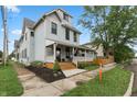 Charming two-story home with a welcoming front porch and manicured landscaping, exuding curb appeal at 1665 N College Ave, Indianapolis, IN 46202