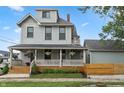 Beautiful home exterior with a spacious front porch, lush landscaping, and a well-maintained yard at 1665 N College Ave, Indianapolis, IN 46202