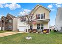 Charming two-story home with a manicured lawn, decorative flowers, and a patriotic American flag displayed on the front porch at 2282 Creekland Dr, Columbus, IN 47201