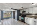 Bright kitchen featuring white cabinets, a black appliance suite, and neutral tile flooring at 3661 Yellow Poplar Ct, Indianapolis, IN 46222