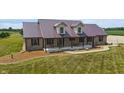 Aerial shot of a brick home featuring a metal roof, covered porch, and professionally landscaped yard at 3777 S 300 E, Anderson, IN 46017