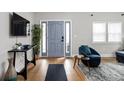 Bright entryway featuring hardwood floors, a blue front door with sidelights, and contemporary furnishings at 5252 N College Ave, Indianapolis, IN 46220