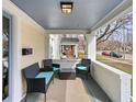 Cozy front porch with seating, neutral rug, and white brick accents, creating a relaxing outdoor space at 5252 N College Ave, Indianapolis, IN 46220