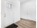 Bright foyer with a windowed front door and wood-look floors, leading to other rooms at 5771 Cr W 750 N, McCordsville, IN 46055