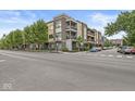 Corner condo featuring brick and siding exterior, multiple balconies, landscaping, and street parking at 622 E 10Th St # 206, Indianapolis, IN 46202