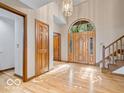 Inviting foyer showcasing hardwood floors, staircase and a large wooden front door with transom window at 6744 Robin Hood Ct, Indianapolis, IN 46227
