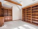 Spacious office with built in shelving and cabinetry, vaulted ceiling, and neutral carpet at 6744 Robin Hood Ct, Indianapolis, IN 46227