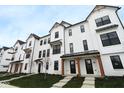 Charming townhomes featuring a white exterior, black-trimmed windows, covered entryway and landscaped front yard at 7081 Pate Hollow Dr, Brownsburg, IN 46112