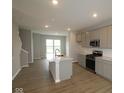 Modern kitchen with stainless appliances, central island, and bright natural light at 7081 Pate Hollow Dr, Brownsburg, IN 46112