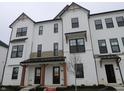 Charming townhome showcasing a bright white exterior with sleek black window trim and dark roofing at 7089 Pate Hollow Dr, Brownsburg, IN 46112