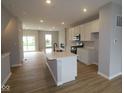 Open-concept kitchen with a central island, stainless steel appliances, and modern white cabinetry at 7089 Pate Hollow Dr, Brownsburg, IN 46112