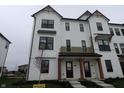 Modern townhome boasts white facade with black accents, offering covered front entries at 7093 Pate Hollow Dr, Brownsburg, IN 46112