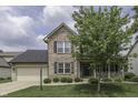 Charming two-story home with brick accents, black shutters, and a well-maintained front yard at 7448 Giroud Dr, Indianapolis, IN 46259