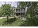 Charming two-story home with brick accents, black shutters, a front porch, and landscaped front yard at 7448 Giroud Dr, Indianapolis, IN 46259