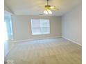 Spacious living room with plush carpeting, large window with blinds, and neutral wall paint at 788 Tulip Ln, Greenwood, IN 46143