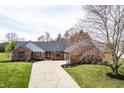 Lovely single story brick home with long driveway, mature trees, and manicured front lawn at 8078 Sunfish Ct, Indianapolis, IN 46236