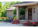 Charming front door with brick columns and colorful roses, framed by manicured landscaping at 9398 W Mirror Rd, Columbus, IN 47201