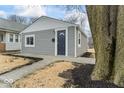 View of a home with modern gray siding and landscaping, featuring a walkway to the entrance at 1049 N Traub Ave, Indianapolis, IN 46222