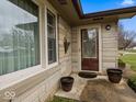 Welcoming front porch featuring a decorative door, planters, and stone facade at 1418 E Maple Dr, Shelbyville, IN 46176