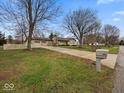 Inviting home with a long driveway, well-manicured lawn, mature trees, and classic mailbox at 1418 E Maple Dr, Shelbyville, IN 46176