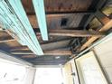 Interior view showing exposed ceiling joists, damaged walls and floors at 1437 Kappes St, Indianapolis, IN 46221