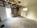 Interior view showing exposed ceiling joists, damaged walls and floors at 1437 Kappes St, Indianapolis, IN 46221