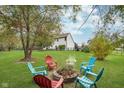 Lush backyard with fire pit surrounded by colorful Adirondack chairs at 15638 River Birch Rd, Westfield, IN 46074