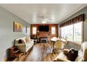 Inviting living room features wood paneling, brick fireplace, wood floors and an abundance of natural light at 207 E Ohio St, Mooresville, IN 46158