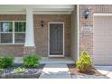 Charming home entryway featuring a welcome mat, brick facade, and attractive landscaping at 2324 Boneset Dr, Plainfield, IN 46168