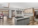 Bright kitchen with granite countertops, tile backsplash, an island cooktop, and modern stainless steel appliances at 2437 W Wavelyn N Cir, Martinsville, IN 46151
